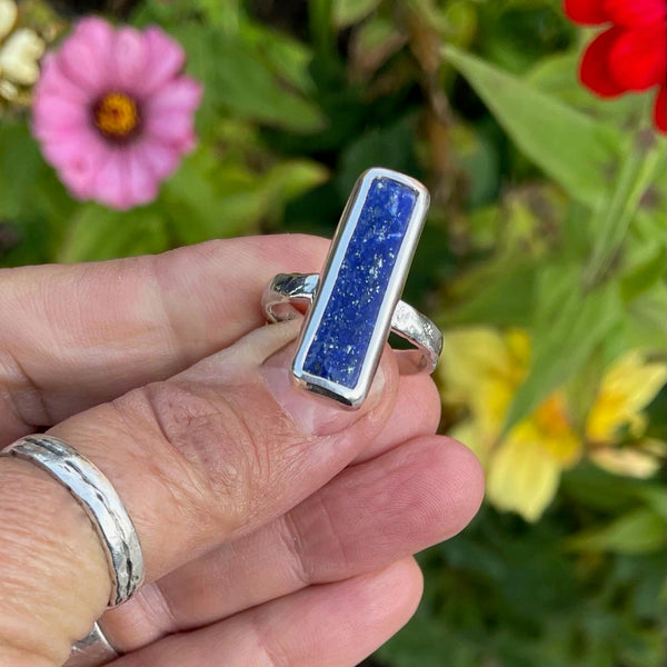 House cut rectangular Lapis Lazuli gem set in textured silver.  Stone is approx 1 inch long and 1/4 inch wide. size 9.75
