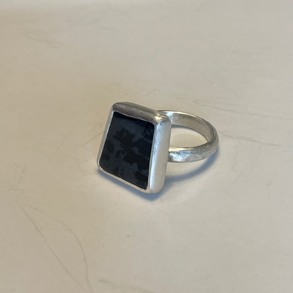 House cut black onyx sets in texture sterling silver band. Stone is natural and has natural marking of grey and black. Stone is shaped in uneven trapeze and Approx. 1.5 cm on it's longer side. Size 8.5