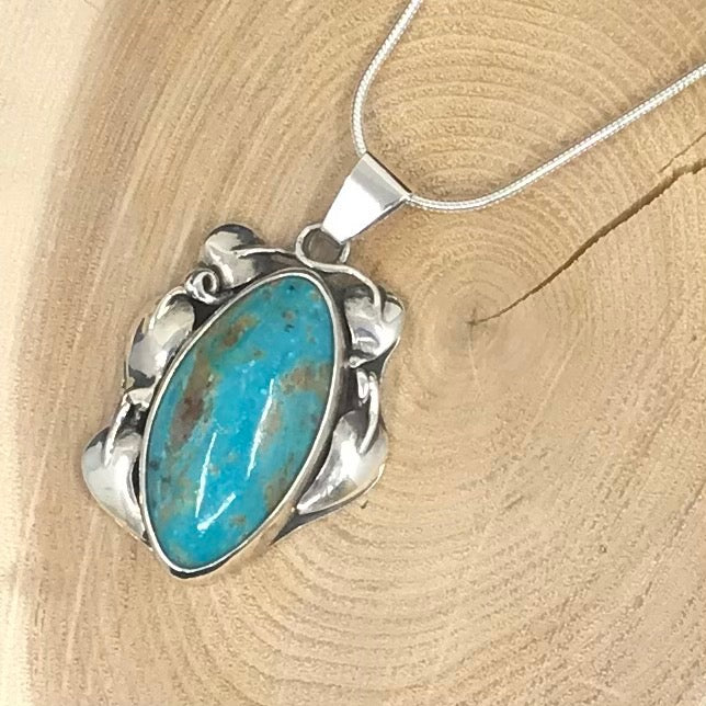 Srling silver pendant with oxidized leaves and turquoise oval stone.